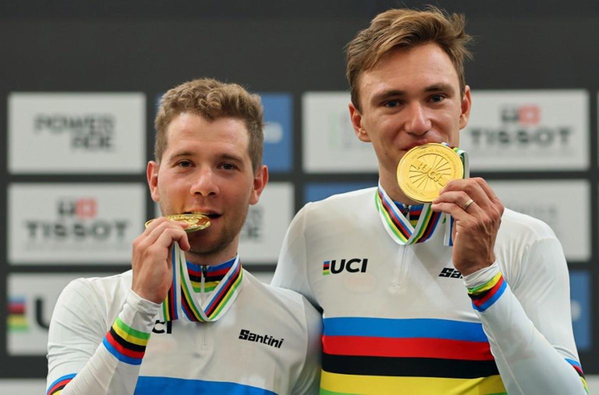 Belgium's Fabio Van den Bossche (L) and Lindsay De Vylder bite their gold medals during the men's madison 50km event award ceremony at the 2025 UCI Track World Championships, in the Penalolen Velodrome in Santiago, on October 26, 2025.  Javier TORRES / AFP