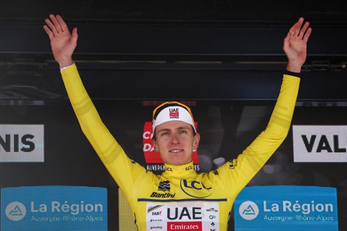 UAE Team Emirates XRG's Slovenian rider Tadej Pogačar wearing the overall leader's yellow jersey celebrates winning the overall race on the podium of the 8th and final stage of the 77th edition of the Criterium du Dauphine cycling race, 133,3 km between Val-d'Arc and Val-Cenis - Plateau du Mont Cenis, on June 15, 2025.  Anne-Christine POUJOULAT / AFP