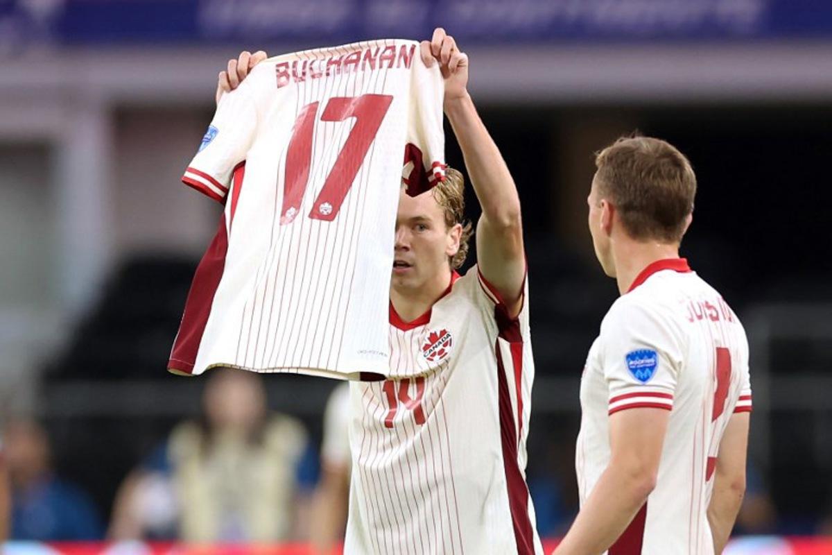 Canada's forward #14 Jacob Shaffelburg celebrates scoring his team's first goal as he holds Canada's forward #17 Tajon Buchanan jersey during the Conmebol 2024 Copa America tournament quarter-final football match between Venezuela and Canada at AT&T Stadium in Arlington, Texas, on July 5, 2024.  CHARLY TRIBALLEAU / AFP