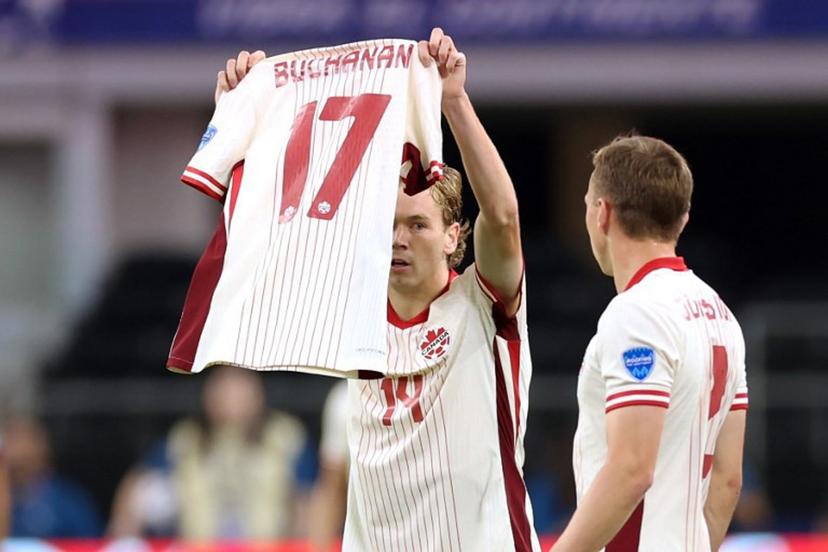 Canada's forward #14 Jacob Shaffelburg celebrates scoring his team's first goal as he holds Canada's forward #17 Tajon Buchanan jersey during the Conmebol 2024 Copa America tournament quarter-final football match between Venezuela and Canada at AT&T Stadium in Arlington, Texas, on July 5, 2024.  CHARLY TRIBALLEAU / AFP