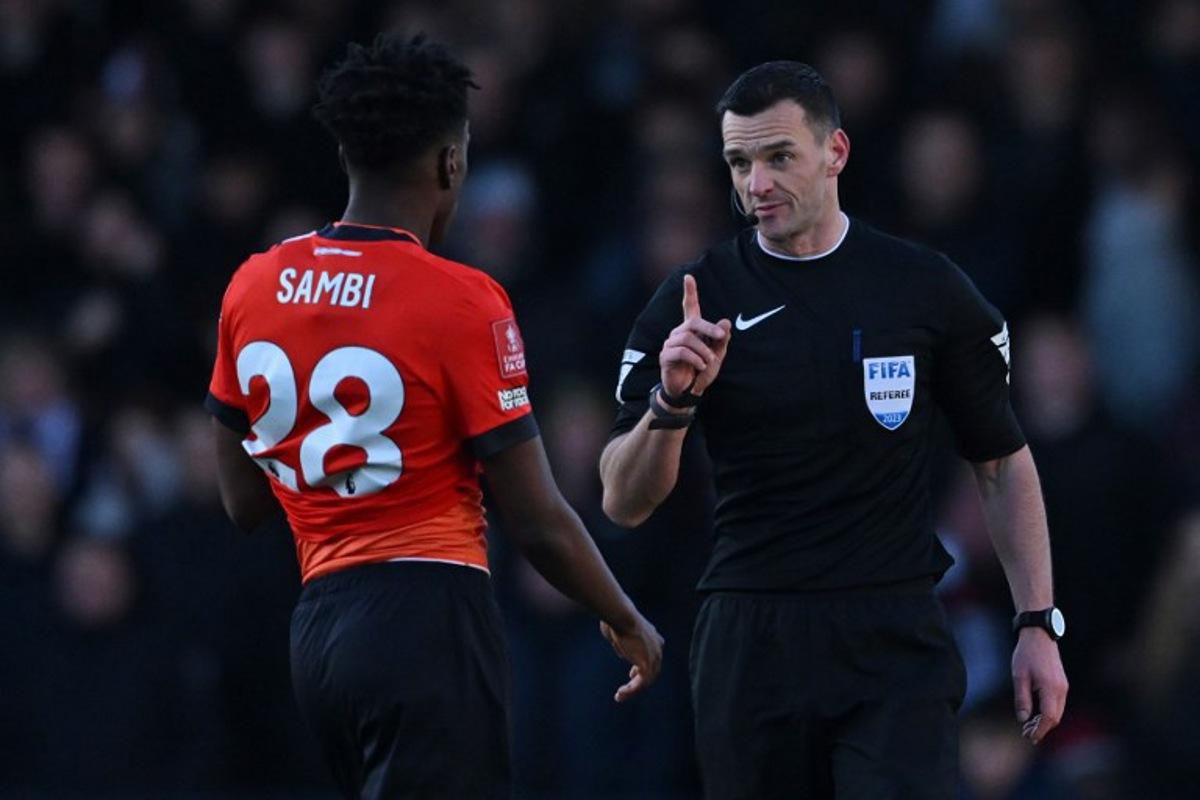 English referee Andrew Madley (R) speaks with Luton Town's Belgiam midfielder #28 Albert Sambi Lokonga during the English FA Cup third round football match between Luton Town and Bolton Wanderers at Kenilworth Road in Luton, north of London on January 7, 2024.  JUSTIN TALLIS / AFP