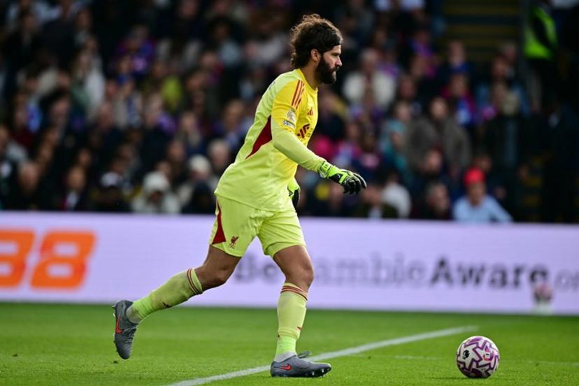 Liverpool's Brazilian goalkeeper #01 Alisson Becker runs with the ball during the English Premier League football match between Crystal Palace and Liverpool at Selhurst Park in south London on September 27, 2025.  Ben STANSALL / AFP
