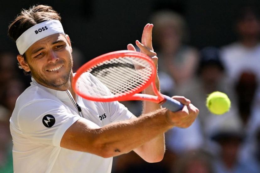 US player Taylor Fritz plays a forehand return to Spain's Carlos Alcaraz during their men's singles semi-final tennis match on the twelfth day of the 2025 Wimbledon Championships at The All England Lawn Tennis and Croquet Club in Wimbledon, southwest London, on July 11, 2025.  Glyn KIRK / AFP