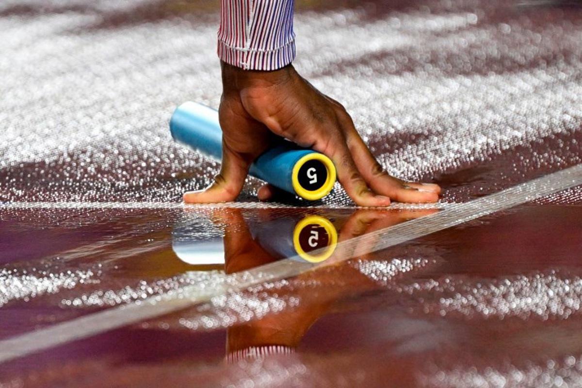 Britain's Efekemo Okoro holds a baton as he competes in the men's 4x400m relay heat during the World Athletics Relays Guangzhou 25 at Guangzhou, in southern China's Guangdong province on May 10, 2025.  WANG Zhao / AFP