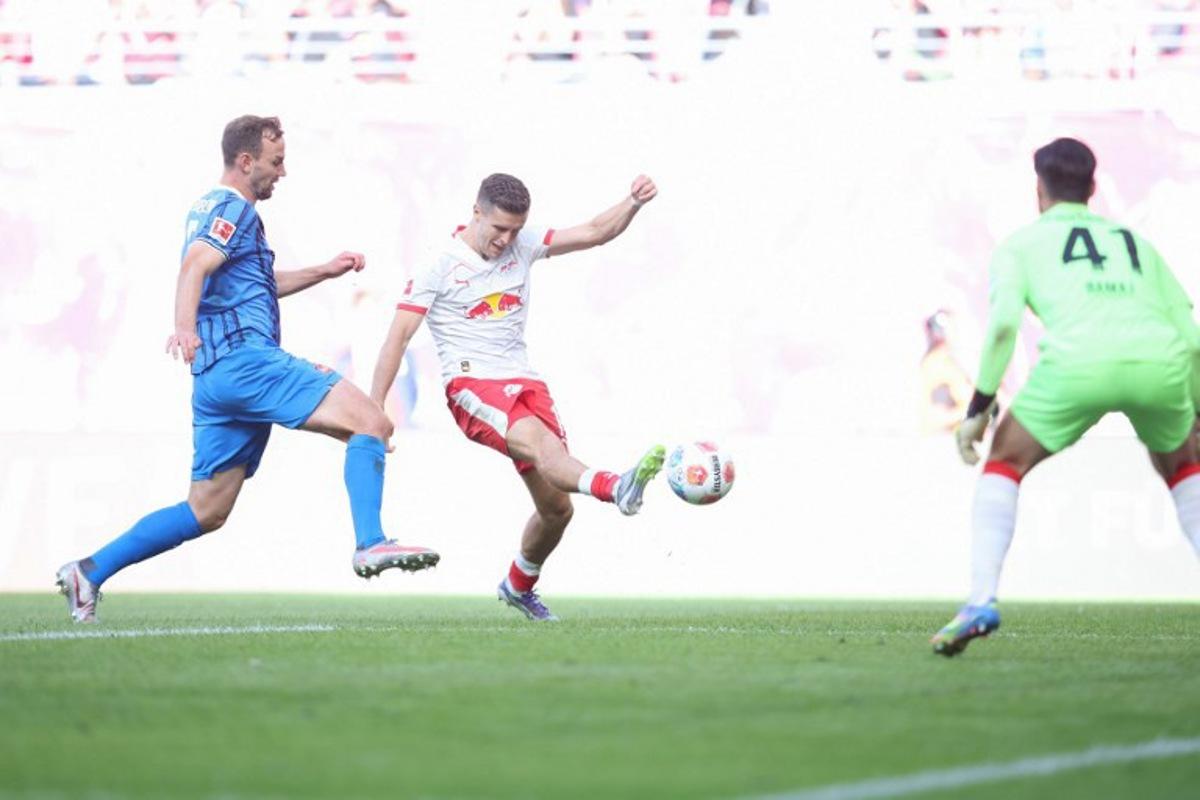 Leipzig's Austrian midfielder #14 Christoph Baumgartner (C) scores the opening goal past Heidenheim's German goalkeeper #41 Diant Ramaj (R) during the German first division Bundesliga football match between RB Leipzig and 1. FC Heidenheim 1846 in Leipzig on August 30, 2025.  Ronny HARTMANN / AFP