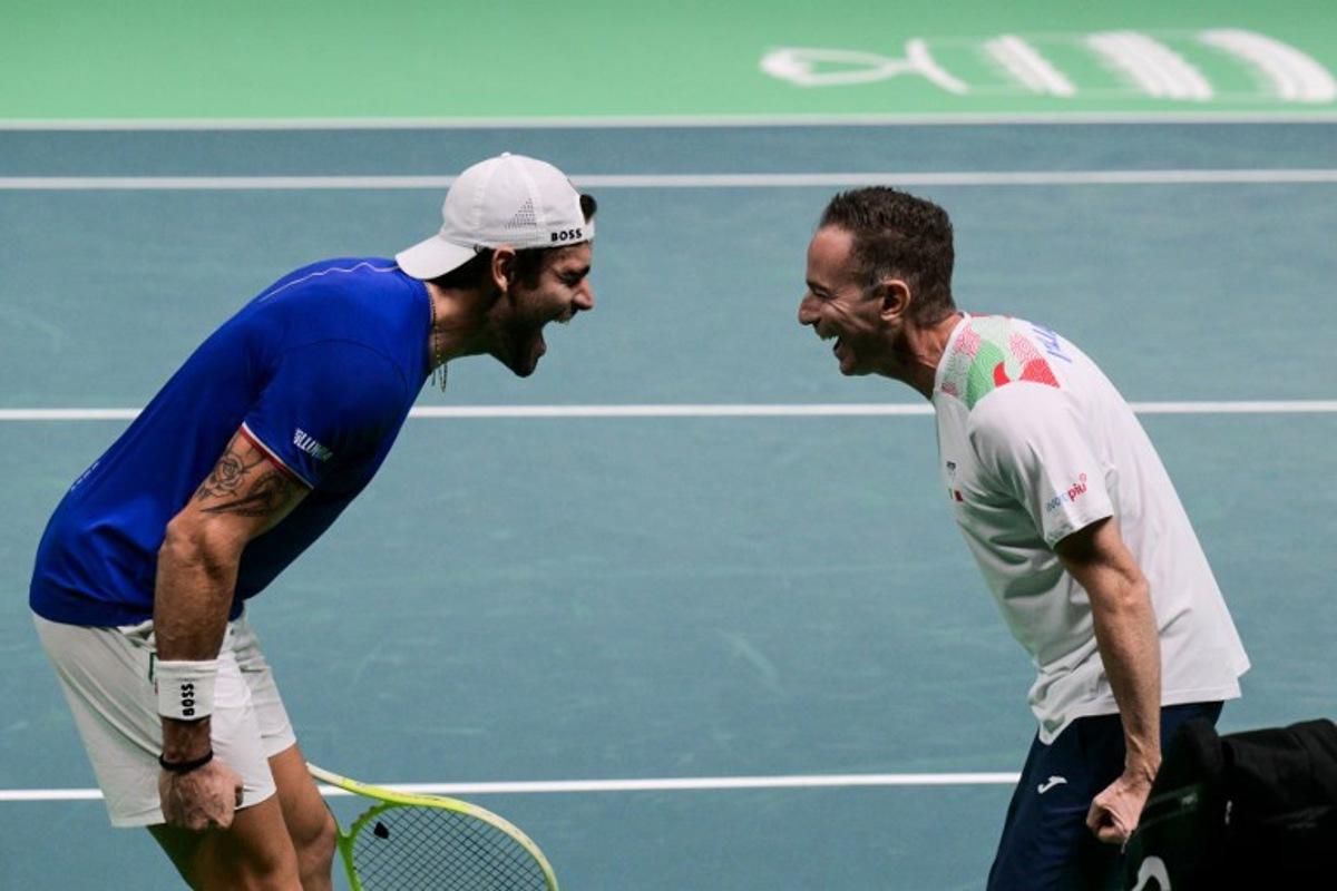 Italy's Matteo Berrettini (L) celebrates with Italy's coach Filippo Volandri after winning against Austria's Jurij Rodionov during their Davis Cup men's singles quarter finals tennis match, at the Super Tennis Arena, in Bologna, northen Italy, on November 19, 2025.  Tiziana FABI / AFP