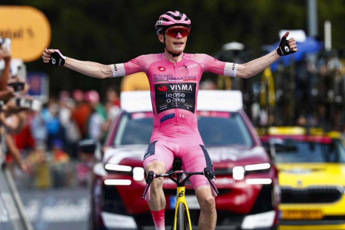 Team Visma Lease a Bike Danish rider Jonas Vingegaard wearing the overall leader's pink jersey (Maglia Rosa) celebrates as he crosses the finish line to win the 16th stage of the Giro d'Italia 2026 - Tour of Italy cycling race between Bellinzona and Cari, Switzerland, on May 26, 2026.  Luca Bettini / AFP