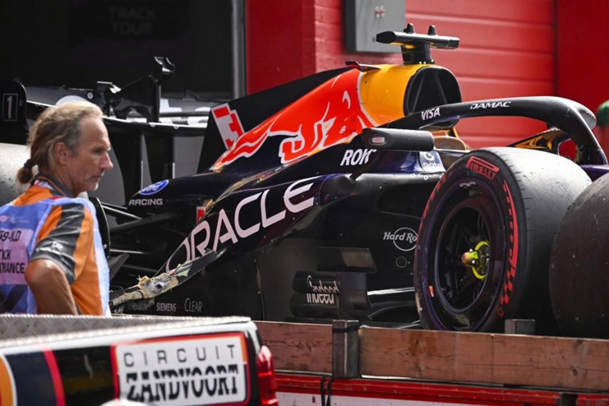 An employee stands next to the crashed car of Red Bull Racing's Dutch driver Max Verstappen during the Formula One Dutch Grand Prix at The Circuit Zandvoort, western Netherlands, on August 23, 2026.  JOHN THYS / AFP