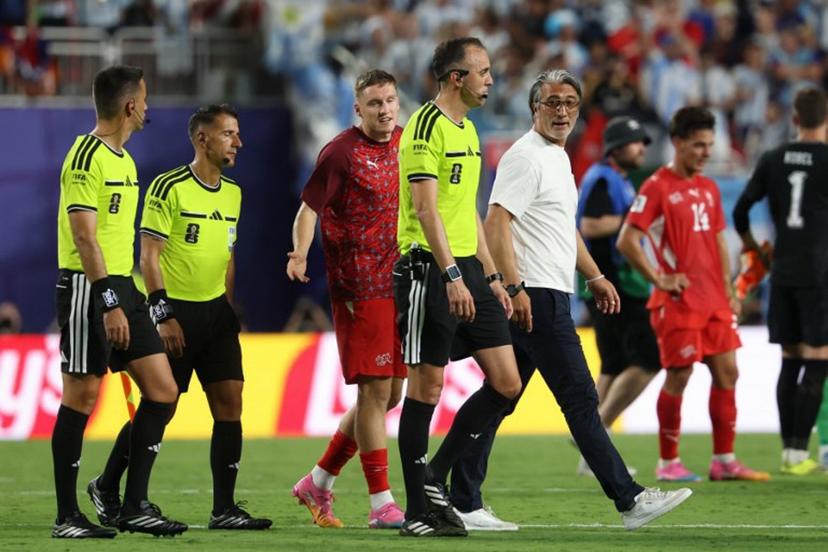 Switzerland's head coach Murat Yakin (R) talks to Portuguese referee Joao Pinheiro at the end of the 2026 World Cup football tournament quarter-final match between Argentina and Switzerland at the Kansas City Stadium in Kansas City on July 11, 2026.   Odd ANDERSEN / AFP
