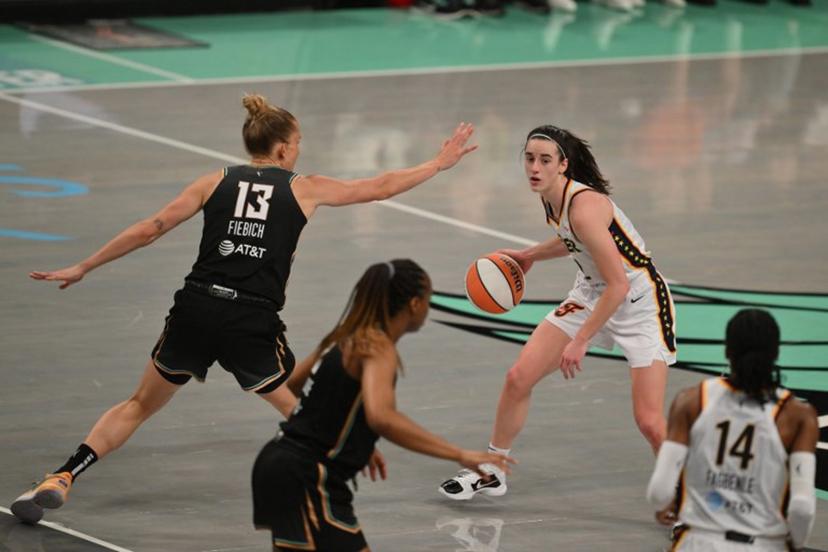 Indiana Fever guard #22 Caitlin Clark (R) dribbles the ball during a WNBA game between the Indiana Fever and New York Liberty, at the Barclays Center in Brooklyn on May 18, 2024, in New York City.  ANGELA WEISS / AFP