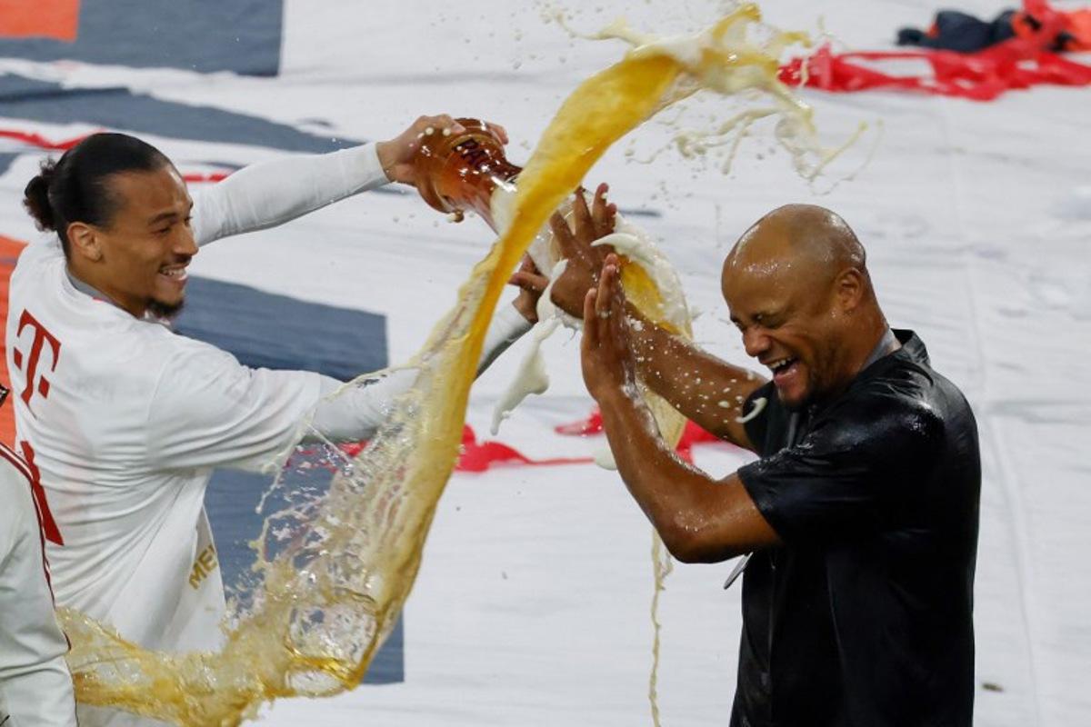 Bayern Munich's German forward #10 Leroy Sane pours beer over Bayern Munich's Belgian head coach Vincent Kompany after the German first division Bundesliga football match between Bayern Munich and Borussia Moenchengladbach in Munich on May 10, 2025.  Michaela STACHE / AFP