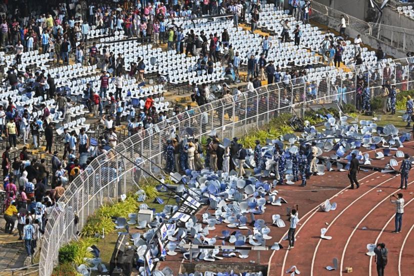 Fans throw chairs as Inter Miami's Argentine forward #10 Lionel Messi departs from the Salt Lake Stadium in Kolkata on December 13, 2025. Thousands of fans packed into a stadium in eastern India on December 13 to cheer on Lionel Messi as the football legend unveiled a 21-metre (70-foot) statue of himself.  Dibyangshu SARKAR / AFP