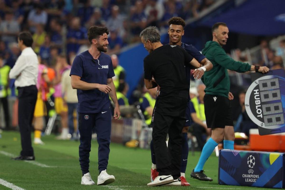 Paris Saint-Germain's French midfielder #14 Desire Doue (2R) is embraced by Paris Saint-Germain's Spanish headcoach Luis Enrique (C) as he is substituted during the UEFA Champions League final football match between Paris Saint-Germain (PSG) and Inter Milan in Munich, southern Germany, on May 31, 2025.  FRANCK FIFE / AFP