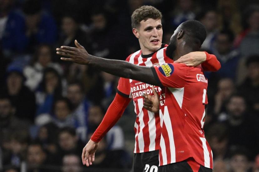 PSV Eindhoven's Dutch midfielder #20 Guus Til (L) celebrates with PSV Eindhoven's Dutch defender #02 Lutsharel Geertruida after scoring the opening goal during the UEFA Champions League first round day 3 football match between FC Porto and PSV Eindhoven at Dragao stadium in Porto, on October 20, 2026  Miguel RIOPA / AFP