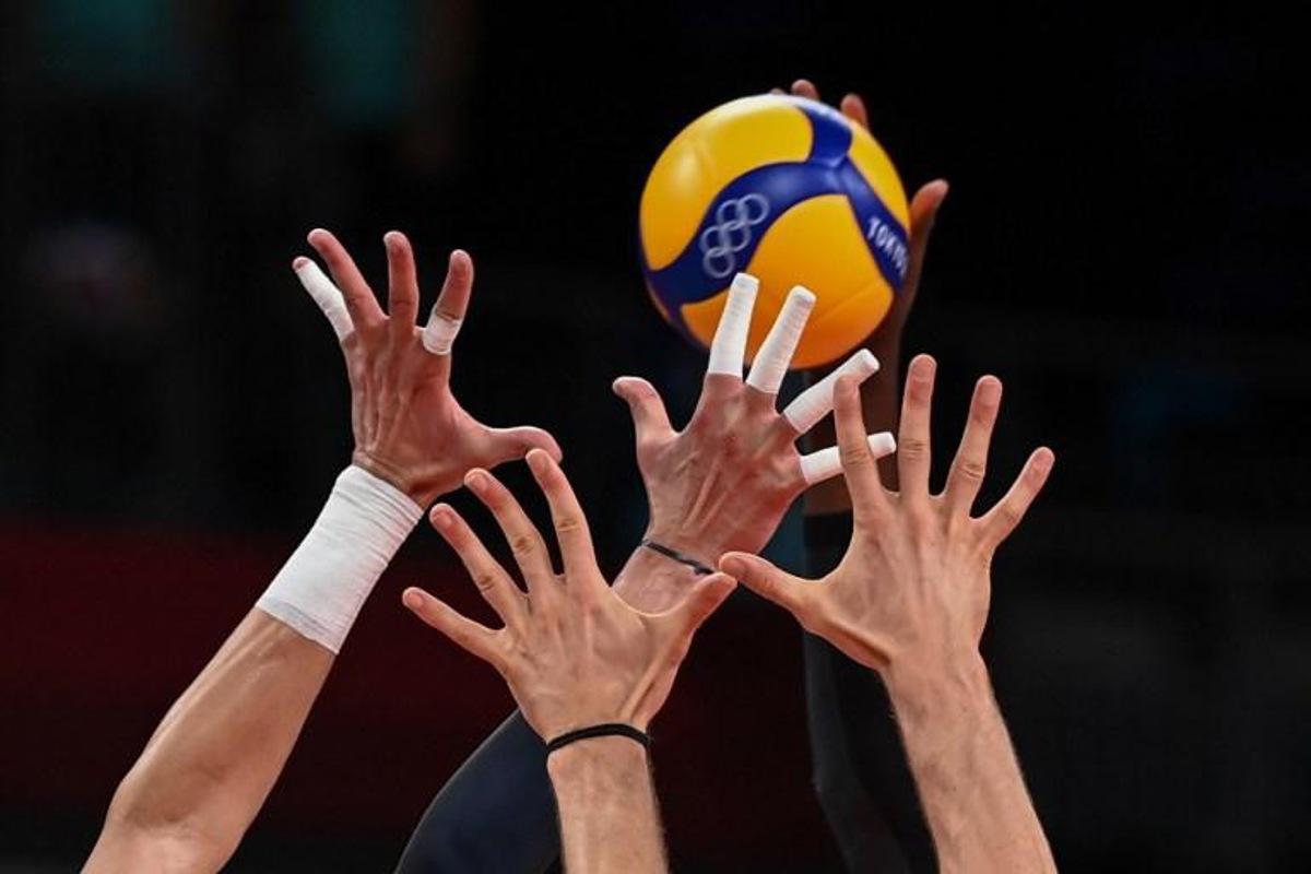 (L-R) Italy's Osmany Juantorena and Italy's Matteo Piano block a shot by Italy's Massimo Colaci in the men's preliminary round pool A volleyball match between Italy and Canada during the Tokyo 2020 Olympic Games at Ariake Arena in Tokyo on July 24, 2021.  YURI CORTEZ / AFP