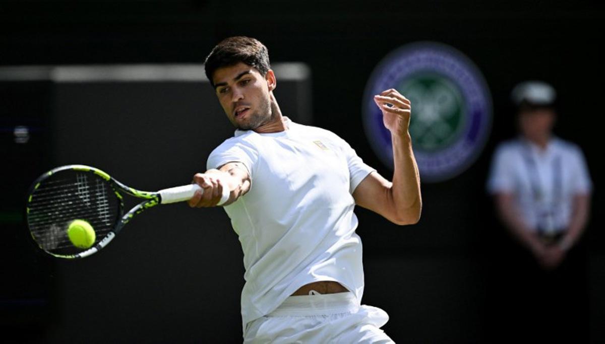 Spain's Carlos Alcaraz plays a forehand return to Britain's Oliver Tarvet during their men's singles second round tennis match on the third day of the 2025 Wimbledon Championships at The All England Lawn Tennis and Croquet Club in Wimbledon, southwest London, on July 2, 2025.  Kirill KUDRYAVTSEV / AFP