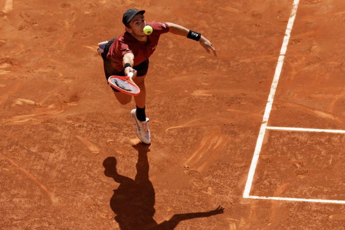 Italy's Matteo Arnaldi returns the ball to Serbia's Novak Djokovic  during their 2025 ATP Tour Madrid Open tennis tournament second round singles match at the Caja Magica in Madrid, on April 26, 2025.  OSCAR DEL POZO / AFP
