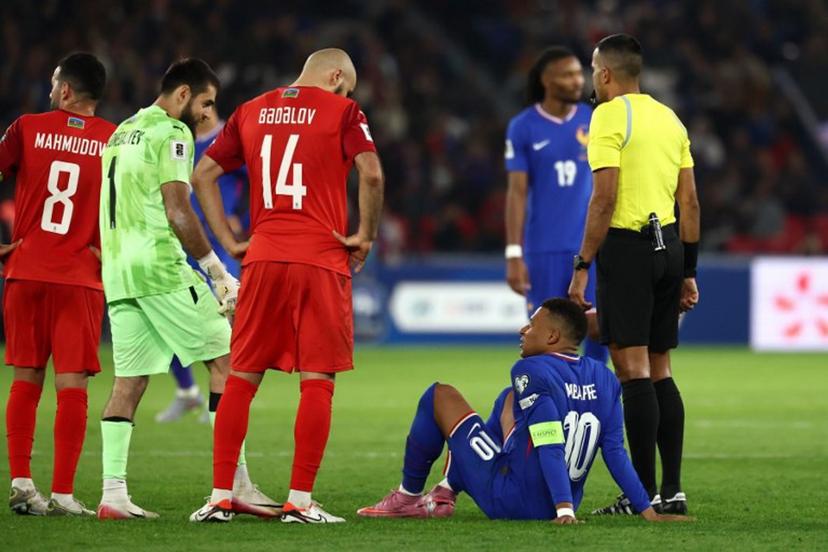 France's forward #10 Kylian Mbappe (2R) talks with Azerbaijan's defender #14 Elvin Badalov (C) and Azerbaijan's goalkeeper #01 Shakhrudin Magomedaliyev (2L) as he sits on the pitch during the FIFA World Cup 2026 Group D European qualification football match between France and Azerbaijan at the Parc des Princes Stadium in Paris, on October 10, 2025.  FRANCK FIFE / AFP