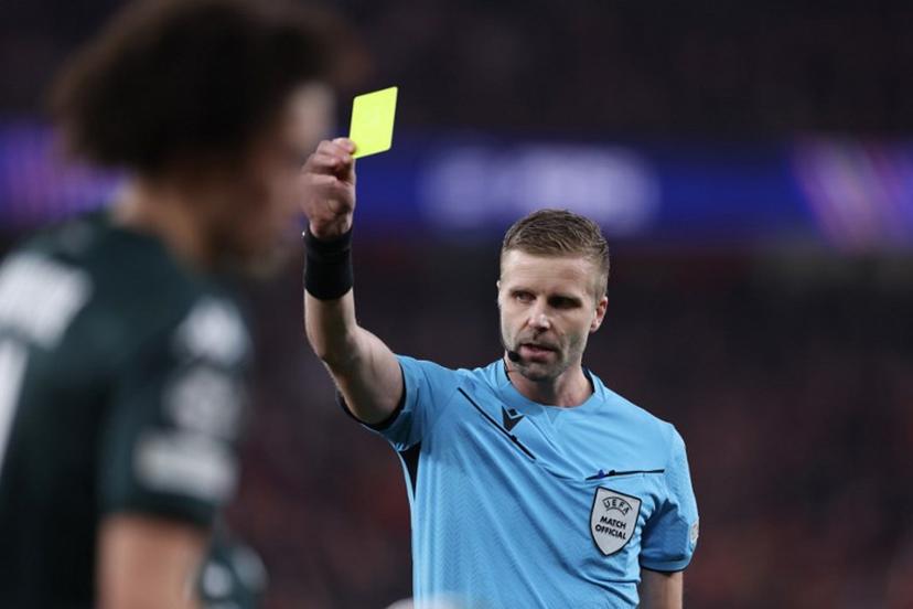 Referee Glenn Nyberg shows a yellow card to Monaco's French midfielder #11 Maghnes Akliouche during the UEFA Champions League knockout phase play-off second leg football match between SL Benfica and AS Monaco at Luz stadium in Lisbon on February 18, 2025.  FILIPE AMORIM / AFP