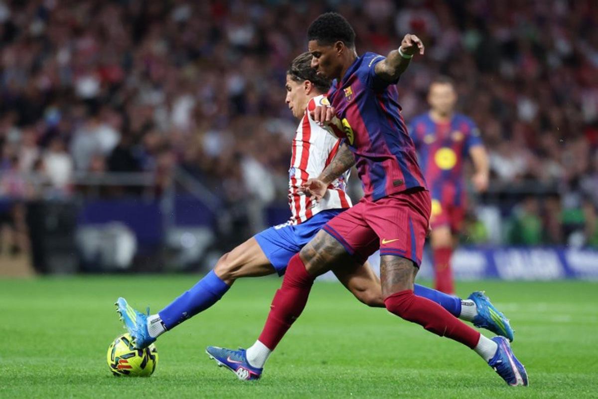 Atletico Madrid's Argentine forward #20 Giuliano Simeone (L) and Barcelona's English forward #14 Marcus Rashford fight for the ball during the Spanish league football match between Club Atletico de Madrid and FC Barcelona at Metropolitano Stadium in Madrid on April 4, 2026.  Pierre-Philippe MARCOU / AFP