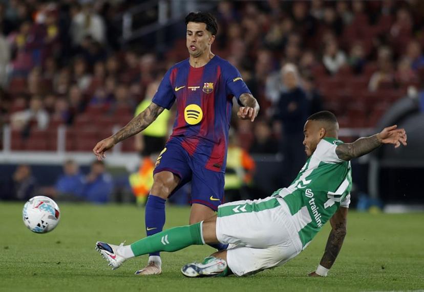 Barcelona's Portuguese defender #02 Joao Cancelo (L) is tackled by Real Betis' Brazilian defender #04 Natan Bernardo de Souza during the Spanish league football match between FC Barcelona and Real Betis at the Camp Nou Stadium in Barcelona on May 17, 2026.  JAIME REINA / AFP