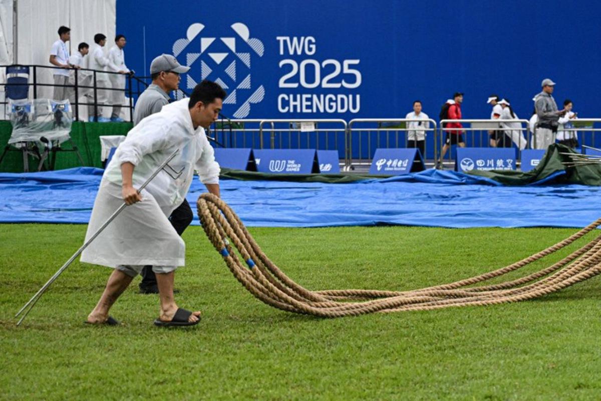 A staff member carries the ropes after the women's outdoor 500kg tug-of-war gold medal match on a rainy day during the 2025 World Games at the Dong'an Lake Sports Park Central Square in Chengdu, in China's southwestern Sichuan province on August 10, 2025.  Jade GAO / AFP