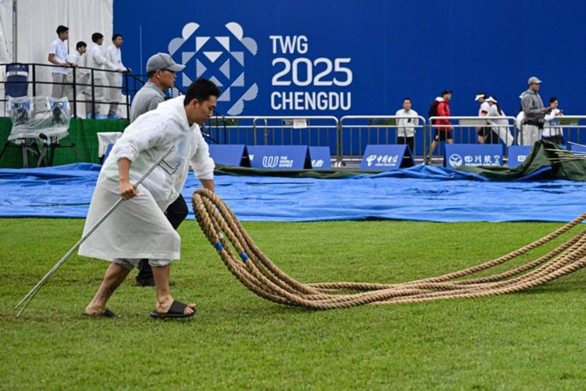 A staff member carries the ropes after the women's outdoor 500kg tug-of-war gold medal match on a rainy day during the 2025 World Games at the Dong'an Lake Sports Park Central Square in Chengdu, in China's southwestern Sichuan province on August 10, 2025.  Jade GAO / AFP