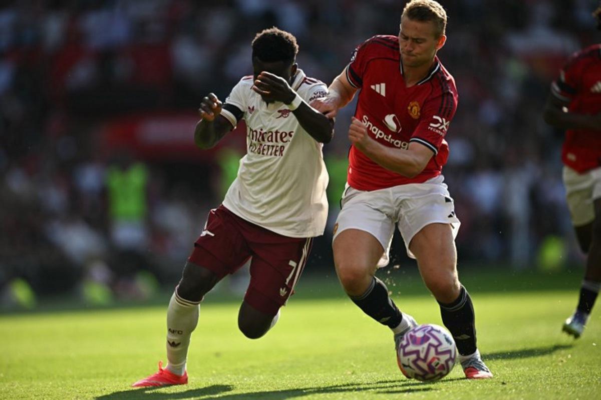 Arsenal's English midfielder #07 Bukayo Saka (L) vies with Manchester United's Dutch defender #04 Matthijs de Ligt (R) during the English Premier League football match between Manchester United and Arsenal at Old Trafford in Manchester, north west England, on August 17, 2025.  Paul ELLIS / AFP