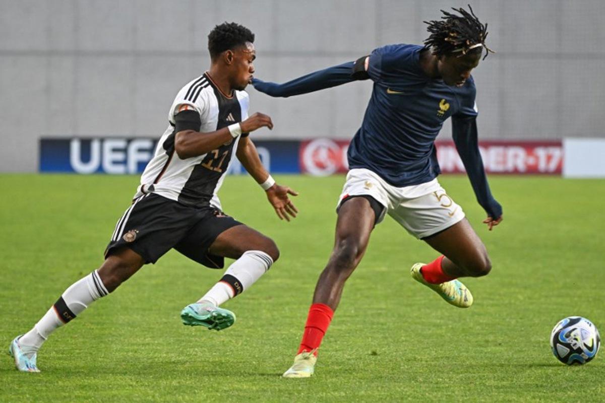 Germany's midfielder Charles Herrmann (L) and France's defender Bastien Meupiyou vie for the ball during the UEFA Under 17 final football match between Germany and France at the Hidegkuti Nandor Stadium in Budapest, Hungary on June 2, 2023.  Attila KISBENEDEK / AFP