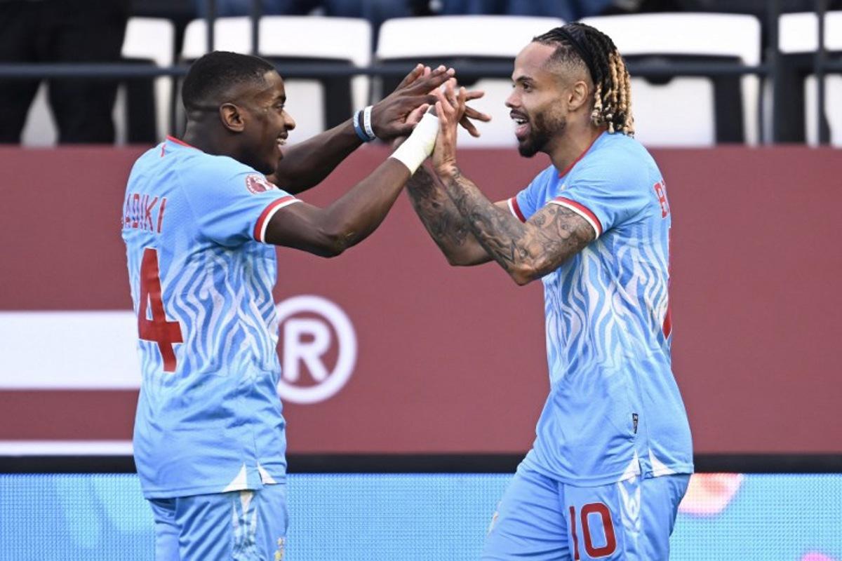 Democratic Republic Of Congo's forward #10 Theo Bongonda celebrates his goal with Democratic Republic Of Congo's midfielder #14 Noah Sadiki during the Africa Cup of Nations (CAN) Group D football match between Democratic Republic of Congo and Benin at Al Medina Stadium in Rabat on December 23, 2025.   SEBASTIEN BOZON / AFP