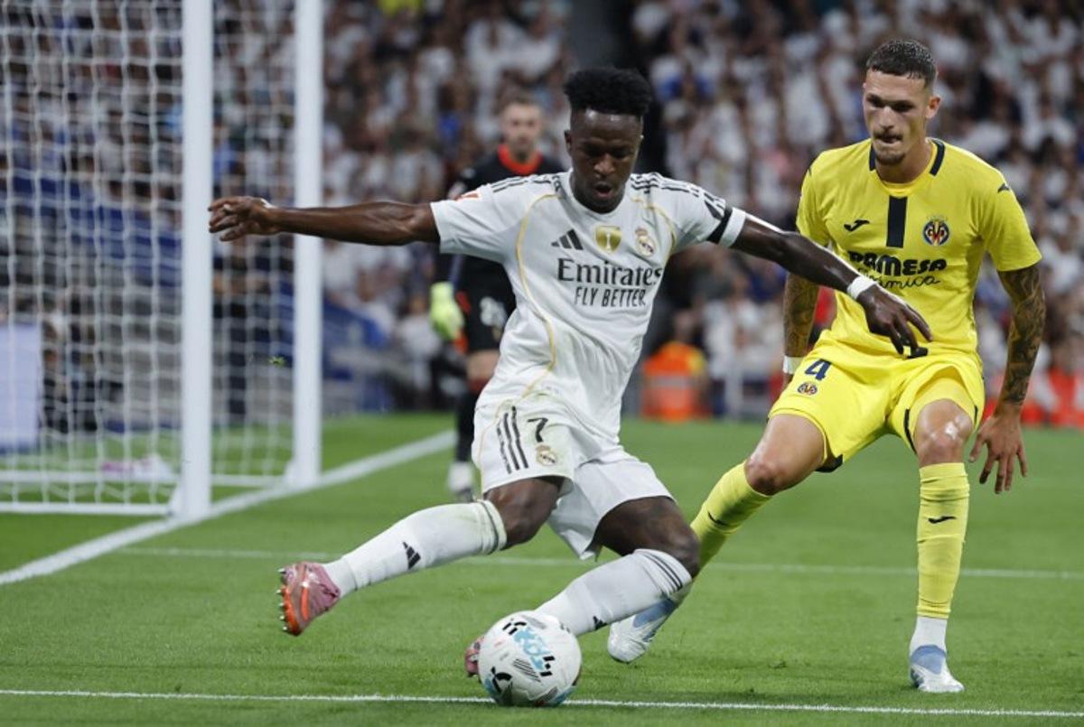 Real Madrid's Brazilian forward #07 Vinicius Junior and Villarreal's Spanish defender #04 Rafa Marin vie for the ball during the Spanish league football match between Real Madrid CF and Villarreal CF at the Santiago Bernabeu stadium in Madrid on October 4, 2025.  Oscar DEL POZO / AFP
