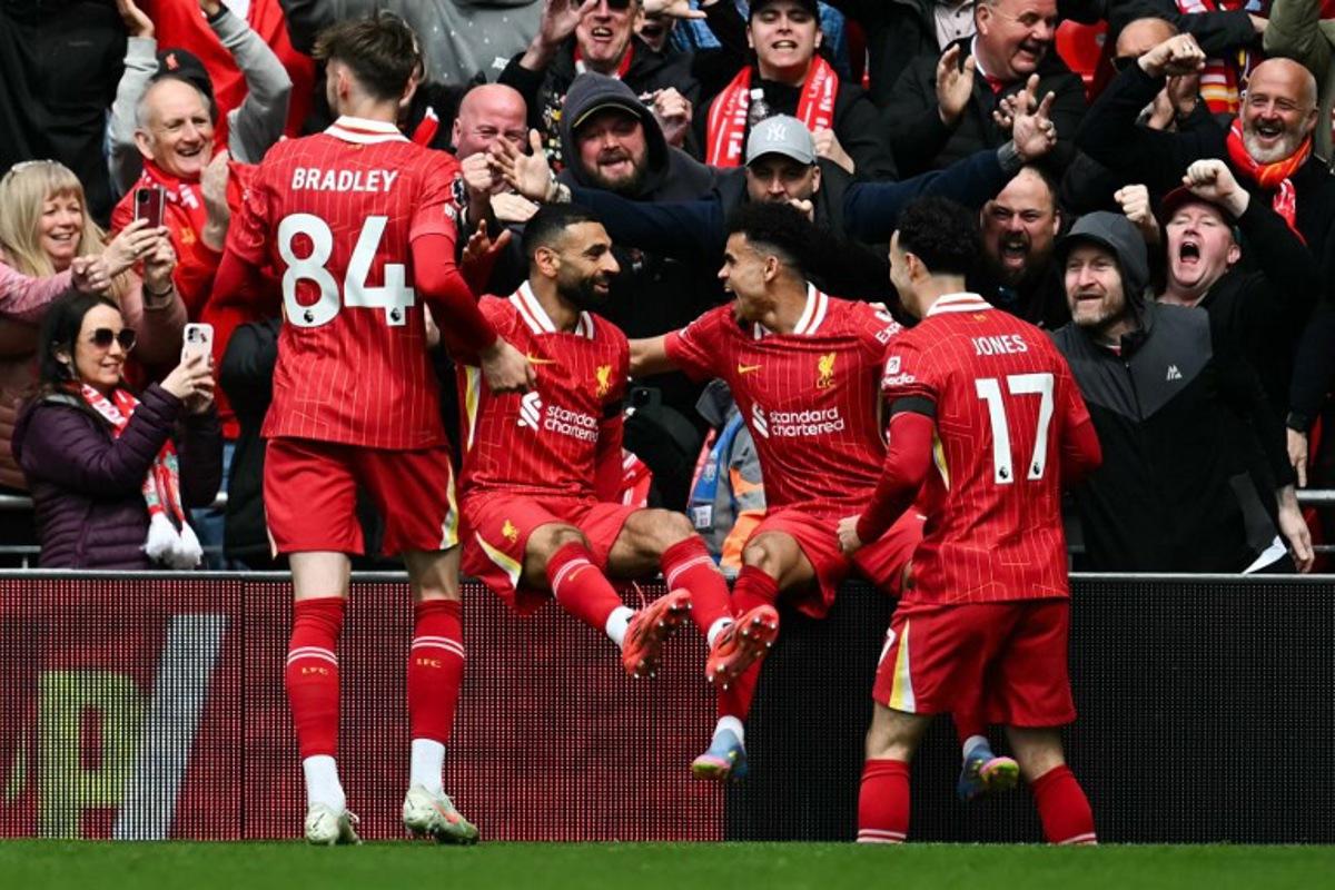 Liverpool's Colombian midfielder #07 Luis Diaz (2nd R) celebrates with Liverpool's English midfielder #17 Curtis Jones (R), Liverpool's Egyptian striker #11 Mohamed Salah and Liverpool's Northern Irish defender #84 Conor Bradley after scoring his team first goal during the English Premier League football match between Liverpool and West Ham United at Anfield in Liverpool, north west England on April 13, 2025.  Paul ELLIS / AFP