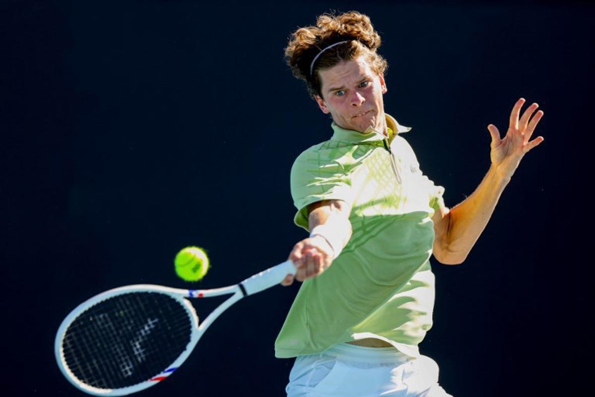 This handout picture released by Tennis Australia on January 18, 2026, shows Belgium's Alexander Blockx hits a return to Portugal's Jaime Faria during their men's singles match on day one of the Australian Open tennis tournament in Melbourne. /DYLAN PARKER  Dylan PARKER / TENNIS AUSTRALIA / AFP