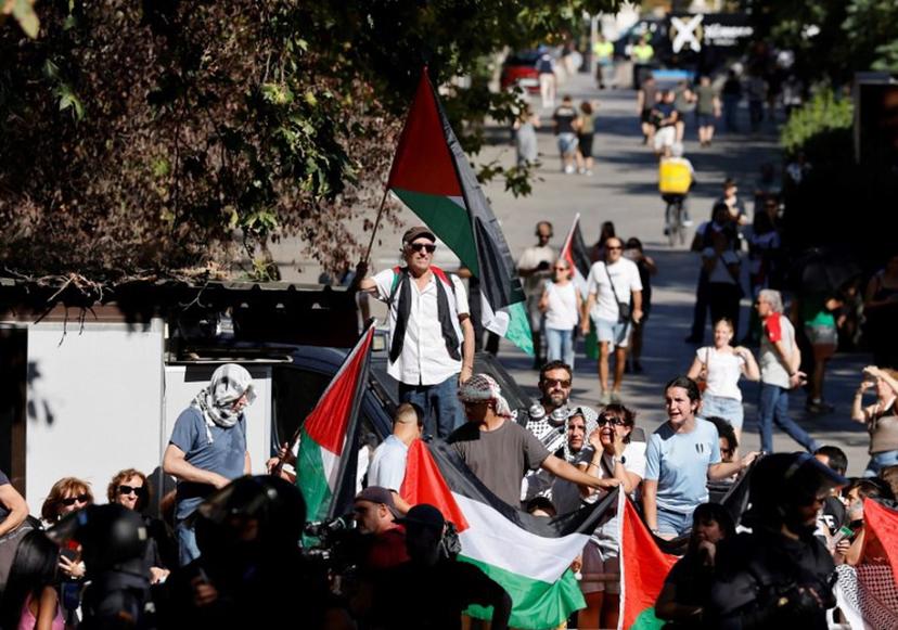 Pro-Palestinians protestors hold Palestinian flags during the 21st and last stage of the Vuelta a Espana 2025, a 101 km race between Alalpardo and Madrid, near Madrid's Atocha train station on September 14, 2025.   The authorities have ramped up security for the Vuelta's final stage in Madrid, which was slightly shortened and will see 1,100 police officers deploy in the Spanish capital. Pierre-Philippe MARCOU / AFP