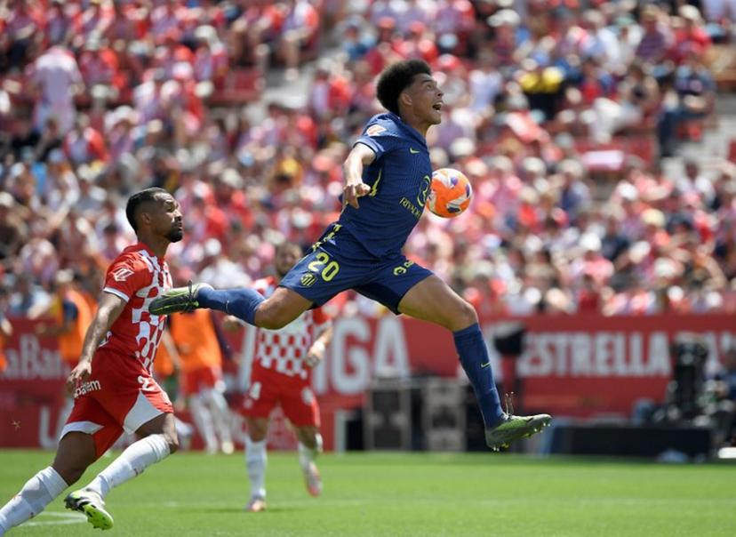 Atletico Madrid's Belgian midfielder #20 Axel Witsel (up) jumps for the ball next to Girona's Venezuelan midfielder #21 Yangel Herrera during the Spanish league football match between Girona FC and Club Atletico de Madrid at Montilivi Stadium in Girona, on May 25, 2025.  Josep LAGO / AFP