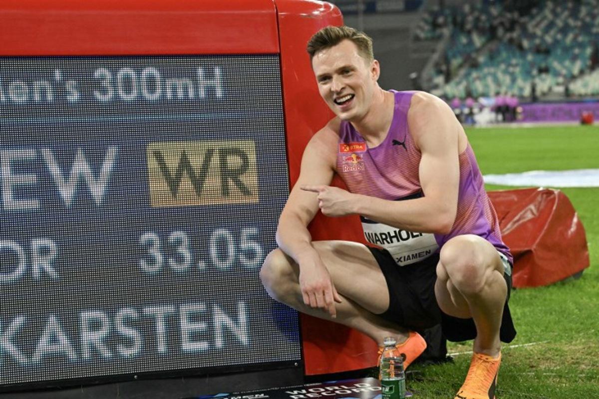 Norway's Karsten Warholm poses with his time of 33.05 seconds after he broke the men's 300m hurdles world record during the Xiamen IAAF Diamond League athletics meeting at Egret Stadium in Xiamen, in China's eastern Fujian province, on April 26, 2025.  ADEK BERRY / AFP