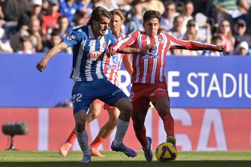 Espanyol's Spanish defender #22 Carlos Romero (L) vies for the ball with Atletico Madrid's Argentine forward #22 Giuliano Simeone during the Spanish league football match between RCD Espanyol and Club Atletico de Madrid at the RCDE Stadium in Cornella de Llobregat on March 29, 2025.  MANAURE QUINTERO / AFP