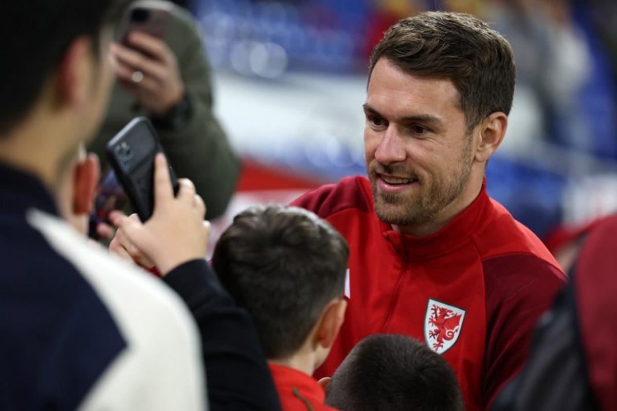 Wales' midfielder Aaron Ramsey poses for a selfie photograph with fans ahead of the UEFA Euro 2024 group D qualification football match between Wales and Croatia at Cardiff City Stadium in Cardiff, south Wales on October 15, 2023.  Adrian DENNIS / AFP