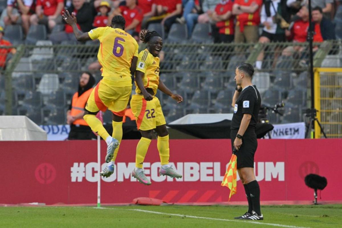 Belgium's forward #22 Jeremy Doku (C) celebrates with Belgium's midfielder #06 Amadou Onana (L) after scoring Belgium's third goal during the FIFA World Cup 2026 Group J European qualification football match between Belgium and Wales at the King Baudouin Stadium in Brussels, on June 9, 2025.  NICOLAS TUCAT / AFP