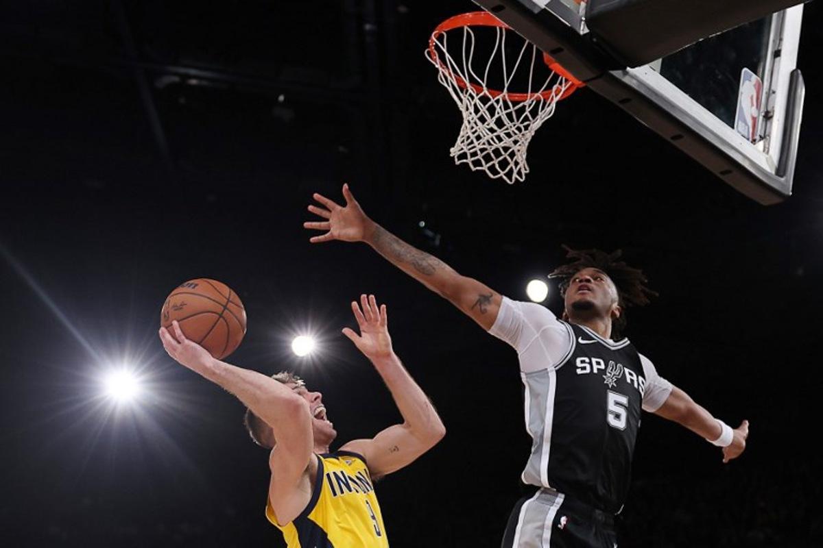 Indiana Pacers' US guard #09 TJ McConnell (L) jumps to the net  as San Antonio Spurs' US guard #05 Stephon Castle (C) defends during the NBA basketball game between the San Antonio Spurs and the Indiana Pacers at the Accor Arena - Palais Omnisports de Paris-Bercy - in Paris on January 25, 2025.  FRANCK FIFE / AFP