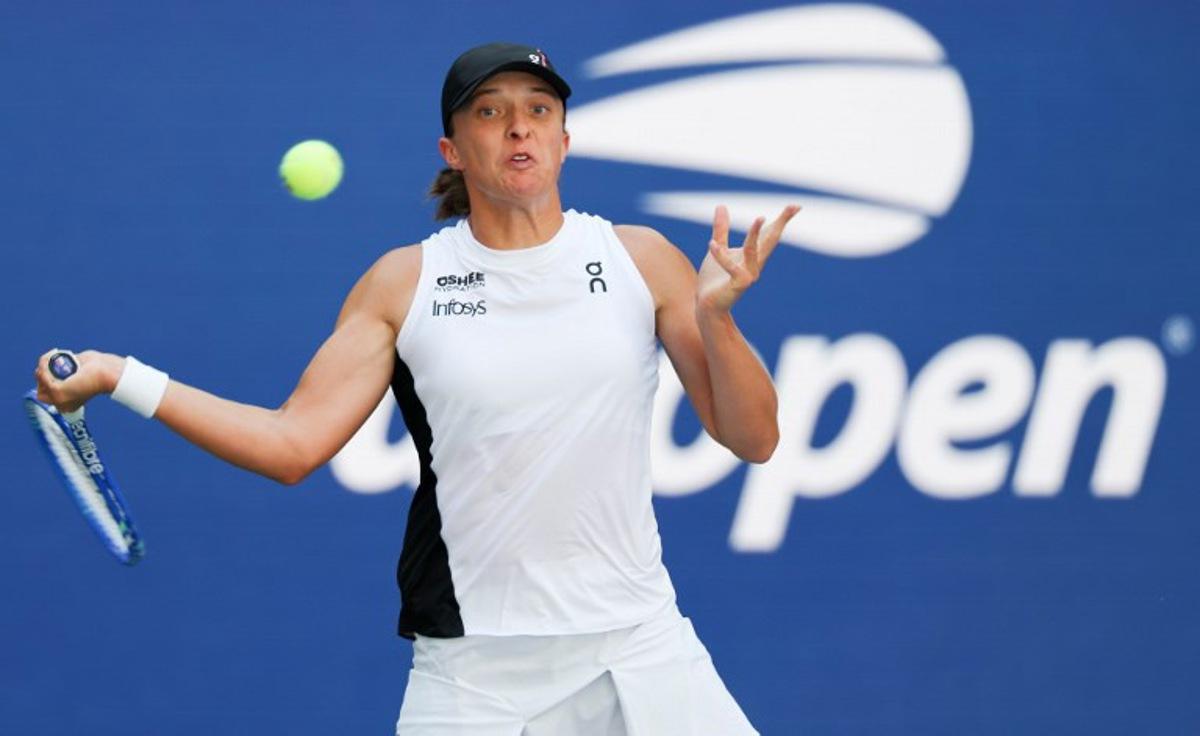 Poland's Iga Swiatek plays a forehand return to Colombia's Emiliana Arango during their women's singles first round tennis match on day three of the US Open tennis tournament at the USTA Billie Jean King National Tennis Center in New York City, on August 26, 2025.  TIMOTHY A. CLARY / AFP
