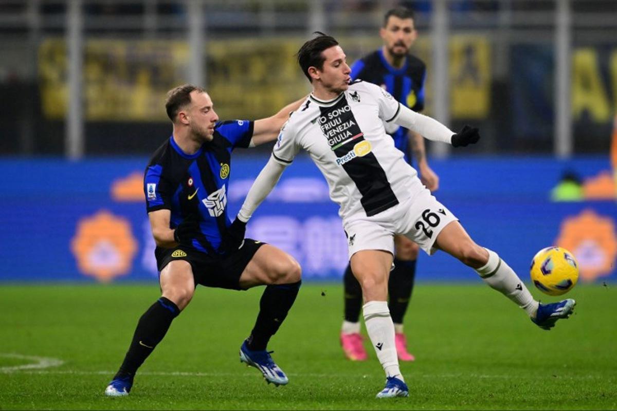 Udinese's French forward #26 Florian Thauvin fights for the ball with Inter Milan's Brazilian defender #30 Carlos Augusto during the Italian Serie A football match between Inter Milan and Udinese at the "San Siro Stadium" in Milan,  on December 9, 2023.  MARCO BERTORELLO / AFP