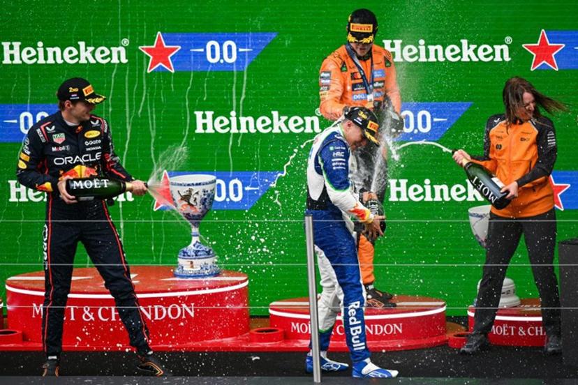 Second-placed Red Bull Racing's Dutch driver Max Verstappen, winner McLaren's Australian driver Oscar Piastri and third-placed RB's French driver Isack Hadjar celebrate on the podium following the Formula One Dutch Grand Prix at The Circuit Zandvoort, western Netherlands, on August 31, 2025.  NICOLAS TUCAT / AFP