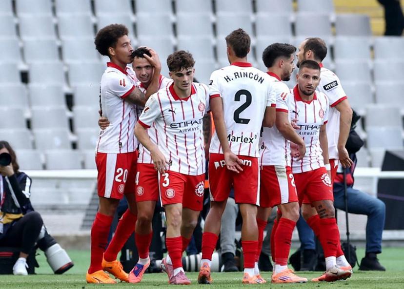 Girona's Belgian defender #20 Axel Witsel celebrates scoring his team's first goal with teammates during the Spanish league football match between FC Barcelona and Girona FC at Estadi Olimpic Lluis Companys in Barcelona on October 18, 2025.  Josep LAGO / AFP