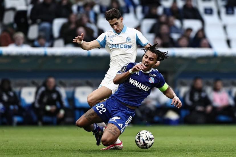 Strasbourg's Ivorian defender #22 Guela Doue (R) is tackled by Marseille's Maroccan defender #21 Nayef Aguerd during the French L1 football match between Olympique de Marseille (OM) and RC Strasbourg at the Stade Velodrome in Marseille, southern France, on February 14, 2026.  Thibaud MORITZ / AFP