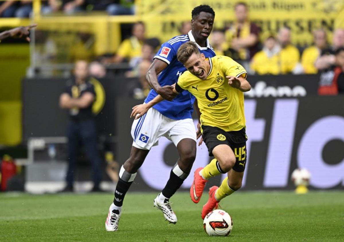 Hamburg's Belgian-Congolese midfielder #06 Albert Sambi Lokonga and Dortmund's Greek midfielder #45 Giannis Konstantelias vie for the ball during the German first division Bundesliga football match between BVB Borussia Dortmund and Hamburg SV in Dortmund, western Germany on August 29, 2026.  INA FASSBENDER / AFP