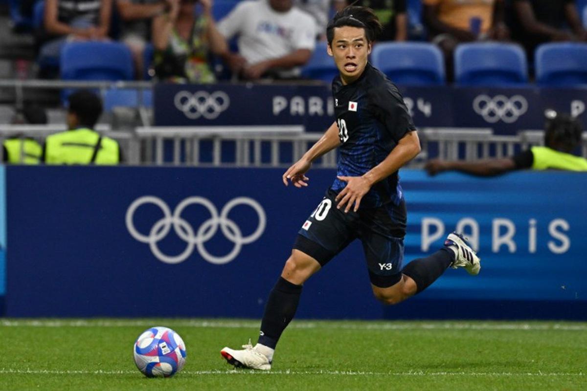 Japan's forward #10 Koki Saito runs with the ball in the men's quarter-final football match between Japan and Spain during the Paris 2024 Olympic Games at the Lyon Stadium in Lyon on August 2, 2024.  Arnaud FINISTRE / AFP