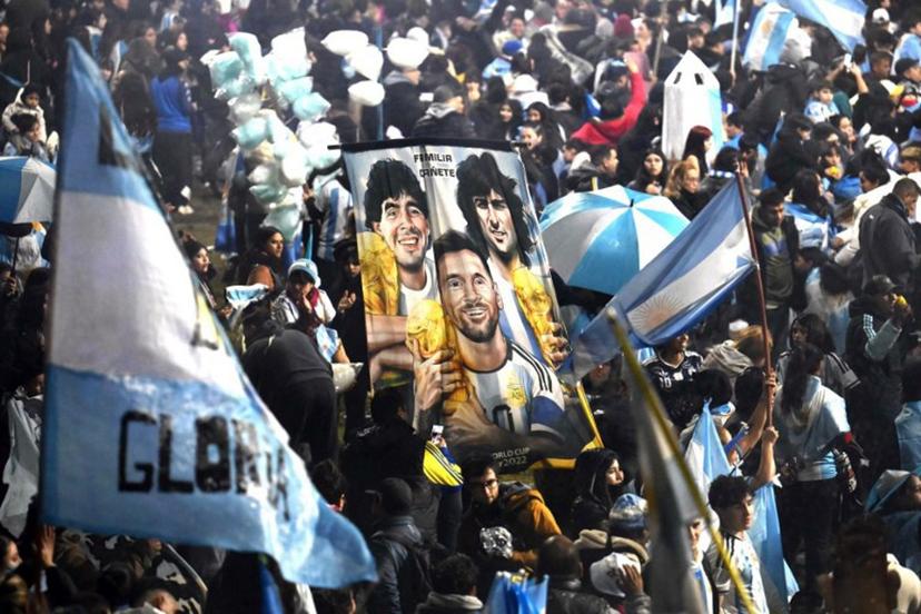 Fans hold a banner depicting Argentine football legends Diego Maradona, Mario Kempes and Lionel Messi holding FIFA World Cup trophies as supporters gather near the Argentine Football Association (AFA) training camp in Ezeiza, Buenos Aires Province, on July 20, 2026, while awaiting the arrival of Argentina's national football team from the United States following its defeat in the 2026 FIFA World Cup final.  Luis ROBAYO / AFP
