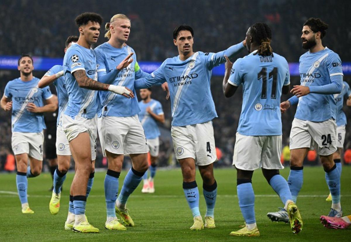 Manchester City's Norwegian striker #09 Erling Haaland (C) celebrates scoring his team's second goal with Manchester City's Belgian midfielder #11 Jeremy Doku (2R) during the UEFA Champions League football match between Manchester City and Borussia Dortmund at the Etihad Stadium in Manchester, north west England, on November 5, 2025.  Oli SCARFF / AFP
