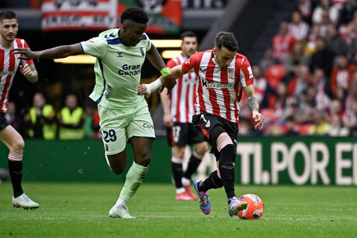 Athletic Bilbao's Spanish forward #07 Alex Berenguer (R) vies for the ball with Las Palmas' Portuguese midfielder #29 Dario Essugo during the Spanish league football match between Athletic Club Bilbao and UD Las Palmas at the San Mames stadium in Bilbao, on April 23, 2025.  ANDER GILLENEA / AFP